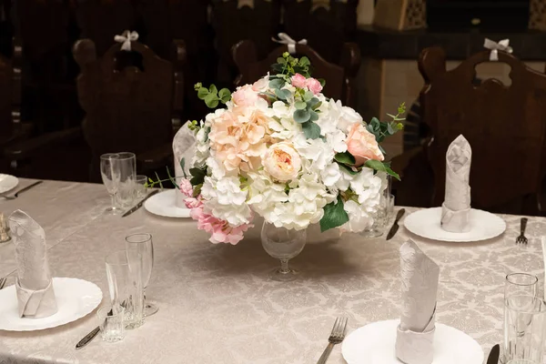 Um buquê de flores em vaso em mesas servidas no casamento. conceito de banquete — Fotografia de Stock