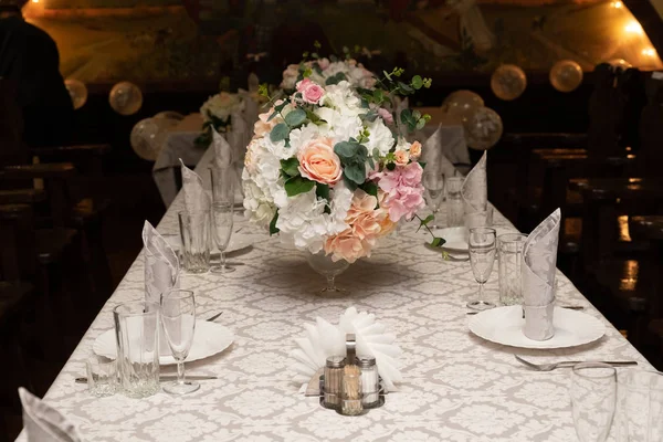 Um buquê de flores em vaso em mesas servidas no casamento. conceito de banquete — Fotografia de Stock