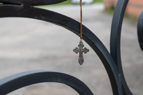Zagubiony krzyż Kościoła wiszący na czarnym metalowym ogrodzeniu świątyni — Zdjęcie stockowe