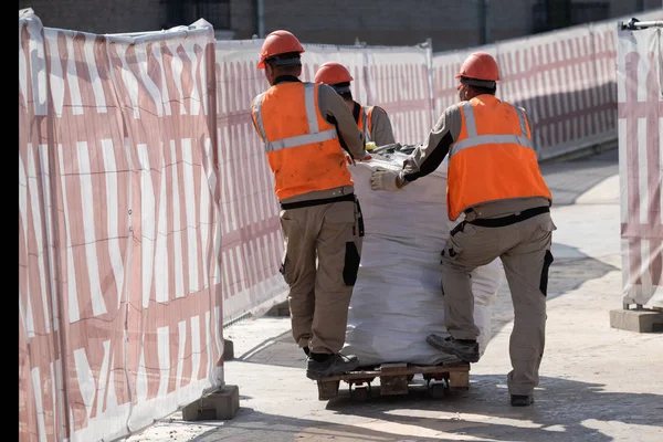 Pembangun mengambil limbah konstruksi dalam tas besar pada pemuat — Stok Foto
