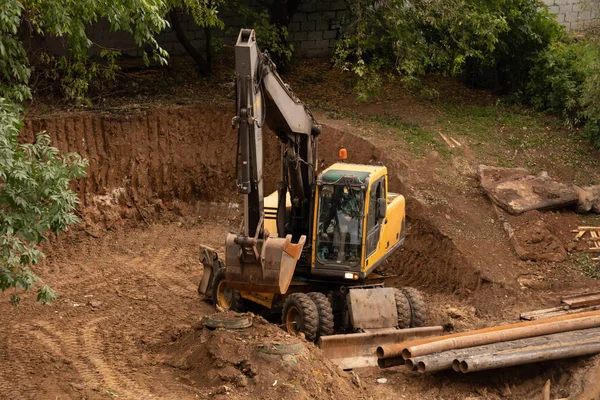 Yükleyici kazıcı, kazıcı kazma bir hendek, Bina şantiyeüzerinde kazı makinesi çalışmaları — Stok fotoğraf