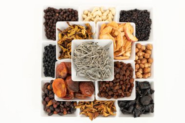 Beyaz arka plan üzerinde kare beyaz kaselerde kurutulmuş meyve çeşitli gruplar