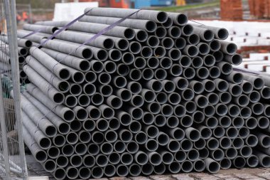 Depodaki metal borular, fotoğrafa yakın çekim. Fabrikada yeni ve parlak çelik boru yığını