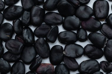 Beyaz arkaplan ve dokuda izole siyah fasulyeleri kapat
