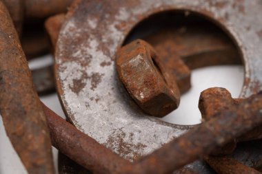 Beyaz zemin üzerinde paslı metal parçalardan oluşan bir dağ. Seçici odak