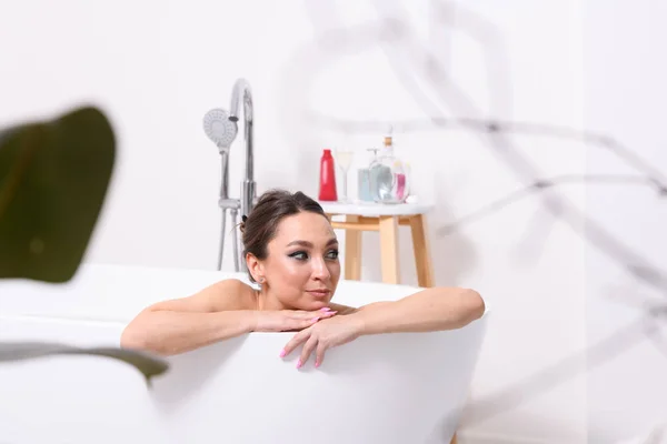 Linda Jovem Deitada Uma Banheira Casa Relaxante Suas Mãos Estão — Fotografia de Stock