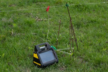 Elektrikli çoban, yakın plan. Ahır, çit, çit, kesilmiş çerçeve. Güneş panellerinden gelen elektrik