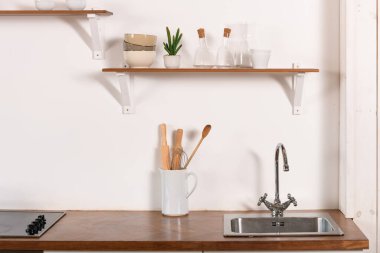 Minimalist İskandinav iç mimarisi. Tabaklar beyaz raflarda. İç kısımda beyaz detaylar.