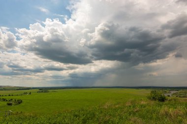 Kuvvetli rüzgar yağmur bulutları sürdü ve ufuk için alanın tamamını doldurdu ve ağır yağıyor bazı yerlerde olduğu gibi belirgindir