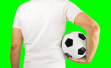 Bir futbol topu onun silah altında tutan genç bir adamın dikiz resim kırpılmış. İzole kesme chroma anahtar yeşil zemin üzerine. Dikiz
