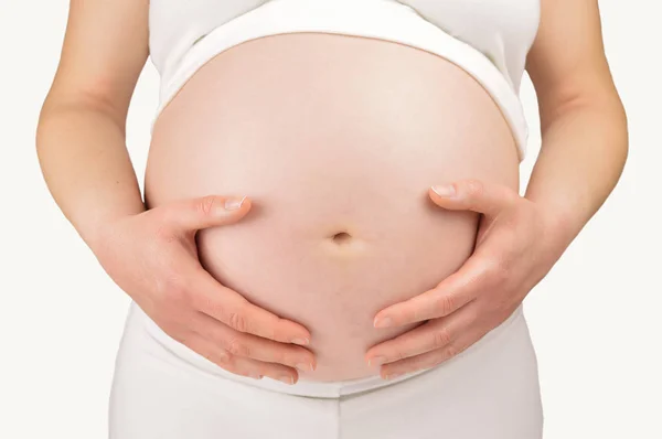 一个怀孕的女人抱着她的肚子中期节特写 — 图库照片
