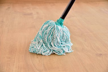 cleaning gear mopping a living room floor with parquet clipart
