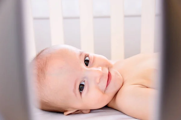 Verspieltes Baby Das Lächelnd Auf Einem Kinderbett Krabbelt — Stockfoto