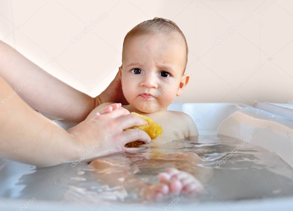 Cropped shot of a angry baby boy being bathed by her mother