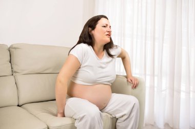 hamile kadın evde koltukta dinleniyor