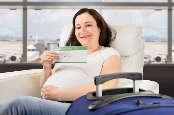 Pregnant woman holding boarding pass waiting for her flight in a VIP area and VIP zone aiport