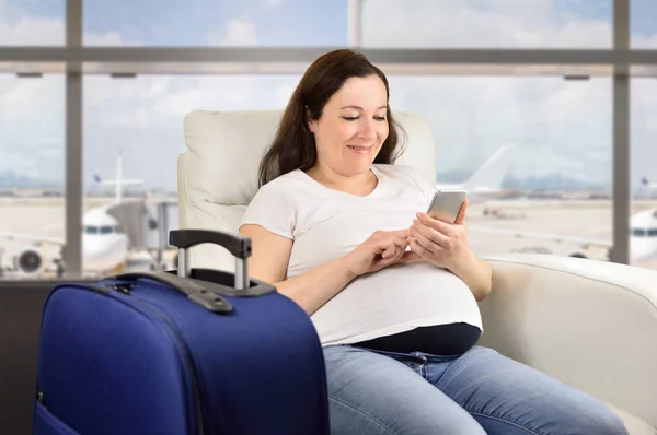 Gravid Kvinna Textning Med Smart Telefon Och Väntar Hennes Flyg — Stockfoto