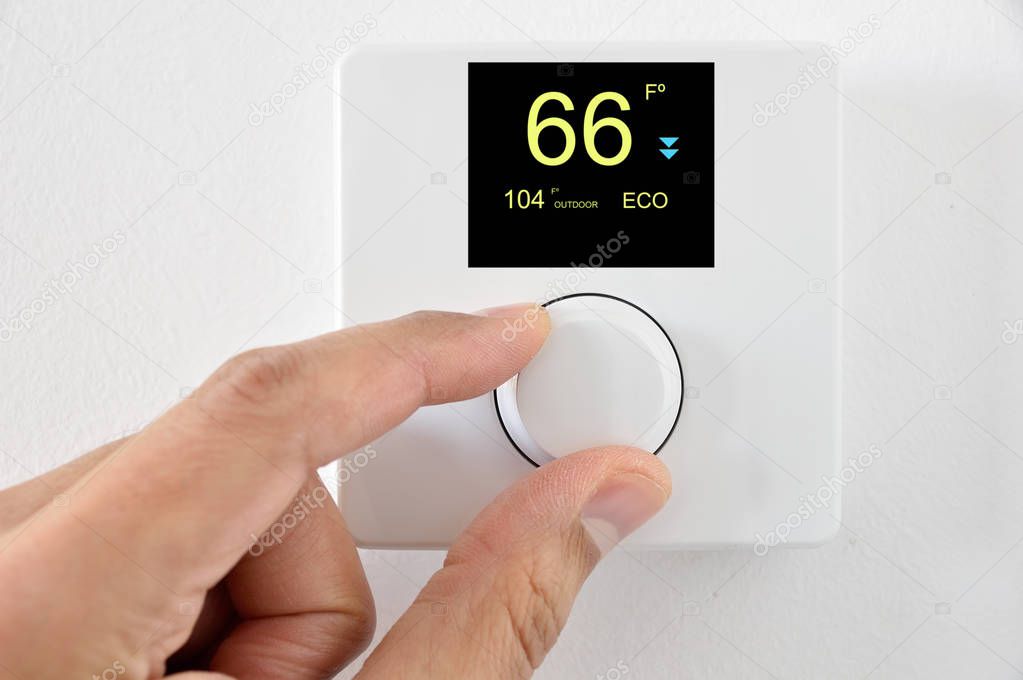 One hand adjust thermostat digital in  fahrenheit at home.Home automation