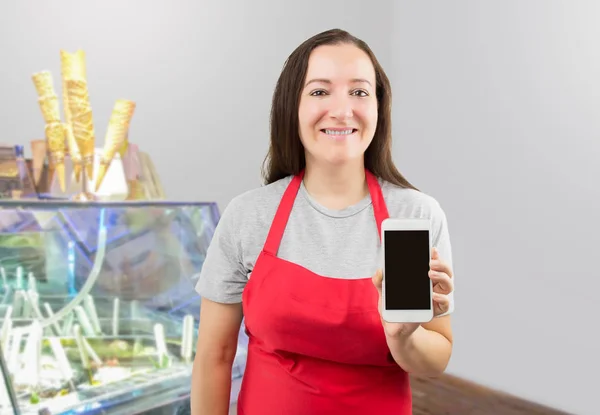 Uśmiechający Się Pracownika Sklepu Lody Stojąc Ladą Sklepie Wyświetlono Telefon — Zdjęcie stockowe