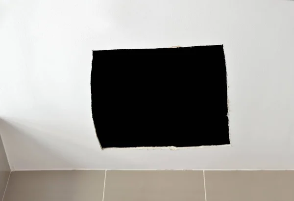 Ceiling panels damaged as a huge hole in the roof from rainwater leakage.