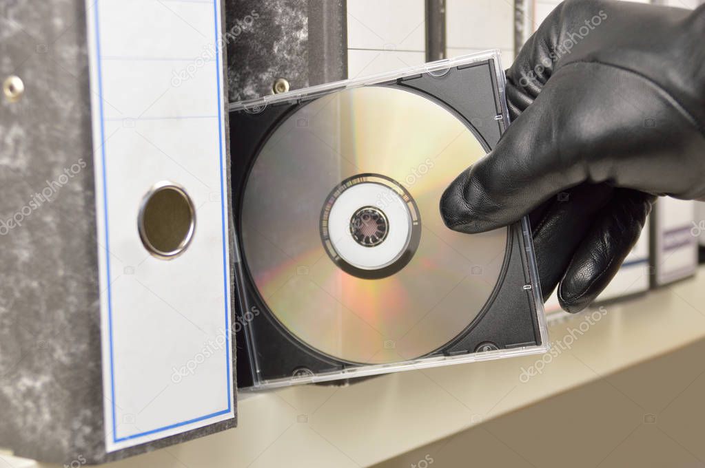 thief stealing in a digitized office files in  compact disk