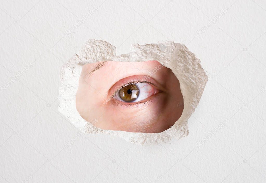 eye looking wall hole close up trapped