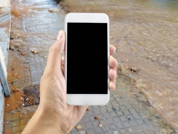 Hand Met Een Telefoon Een Straat Overspoeld Met Water Door — Stockfoto