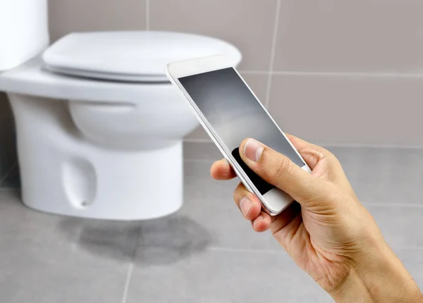 Hand Holding Smartphone Call Professional Repair Water Leak Toilet — Stock Photo, Image