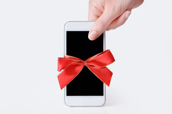 Hand Holding Phone Gift Red Ribbon White Background — Stock Photo, Image