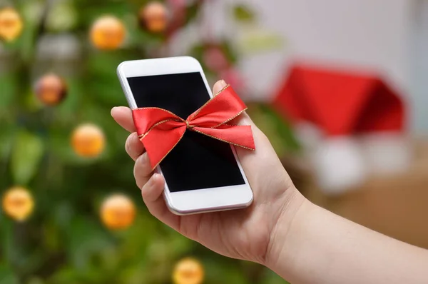 Ruka Ukazuje Chytrý Telefon Pozadím Vánoční Stromeček Doma — Stock fotografie