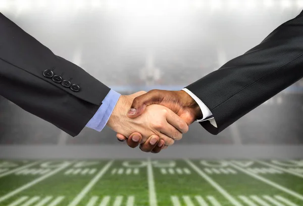Shot of two unrecognizable men greeting each other with a handshake on a business in the sport of football