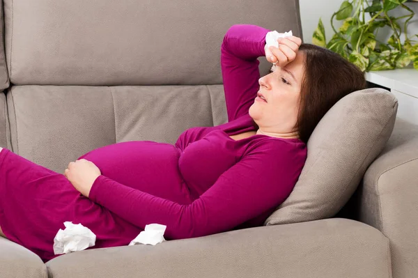 Mujer Embarazada Con Mano Frente Sufriendo Dolor Cabeza Sentada Sofá —  Fotos de Stock