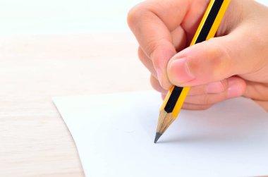 Elinde kağıt üzerinde yazılı kalem