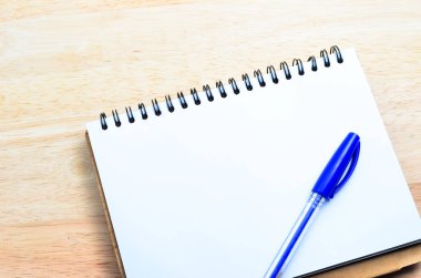 ofis ahşap masa üstünde kalem ile boş bir not defteri