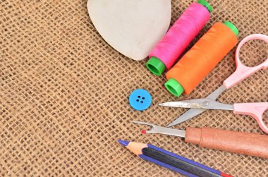 Dikiş takımı. Makas, bobin iplik ve eski kumaş üzerine iğne ile