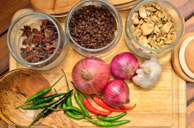 Pişirme malzemeleri. Baharat ve otlar ile soğan ve sarımsak ahşap tahta üzerinde