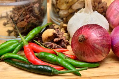 Pişirme malzemeleri. Baharat ve otlar ile soğan ve sarımsak ahşap tahta üzerinde