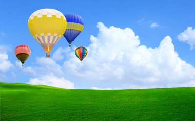 Sıcak hava balonu gökyüzüne yeşil çim üzerinde yüzen