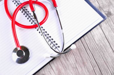 Stetoskop günlüğü kitap ahşap arka plan üzerinde