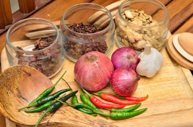 Pişirme malzemeleri. Baharat ve otlar ile soğan ve sarımsak ahşap tahta üzerinde