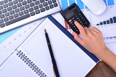 Hesap makinesi ile grafik, grafik, klavye, fare üzerinde ahşap masa üzerinde el