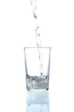 Tatlı su bir bardak beyaz zemin üzerine dökülen