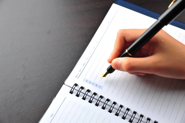 Hand met pen een notitie rekening met kalender — Stockfoto