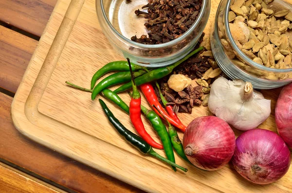 Pişirme malzemeleri. Baharat ve otlar ile soğan ve sarımsak ahşap tahta üzerinde