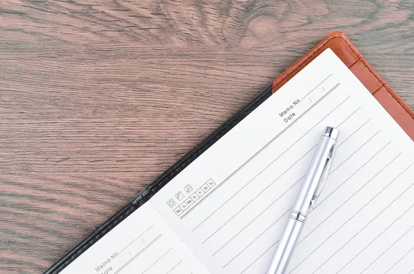 Kalem ve ahşap masa üstünde not etmek