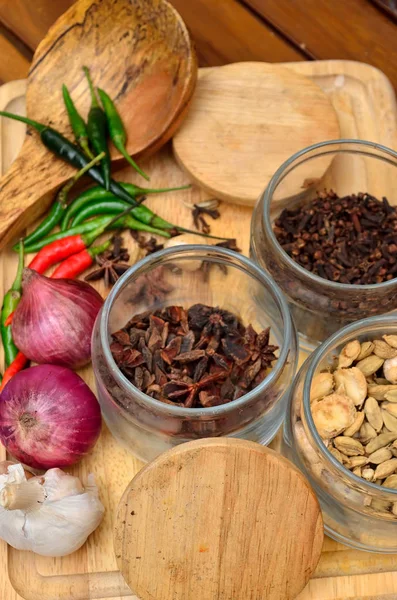 Pişirme malzemeleri. Baharat ve otlar ile soğan ve sarımsak ahşap tahta üzerinde