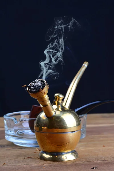 Hookah Coppery Smoking Filter with Tobacco Pipe on wooden tables