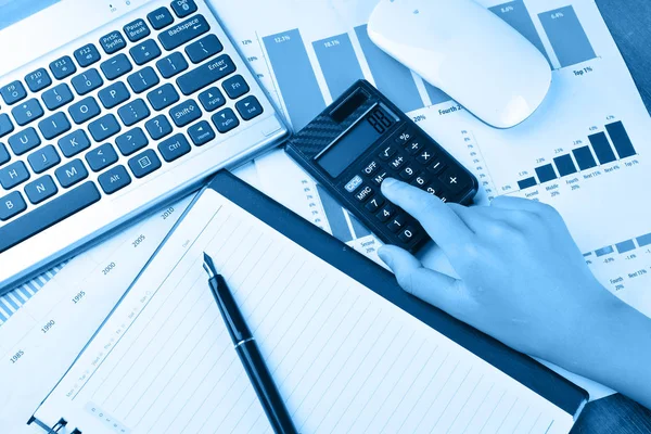 Hesap makinesi ile grafik, grafik, klavye, fare üzerinde ahşap masa üzerinde el