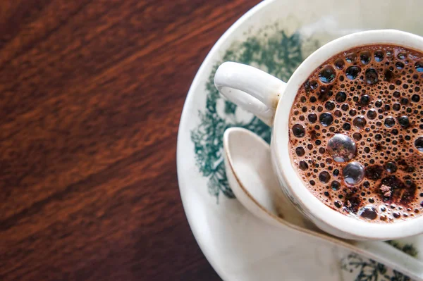 Ahşap yüzeyde sıcak çikolata bir fincan. Yumuşak odak, seçici odak (buble odaklanmış durumdayken) ve sığ derinlik-in tarla (büyük diyafram)