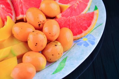 Yakın kadar olan Bouea oppositifolia, greyfurt ve mango siyah arka plan üzerine